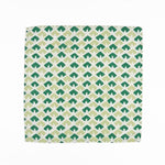 White cloth dinner napkins featuring geometric green triangle patterns in two shades for stylish tablescapes.