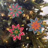 Three Colorful jeweled flower Christmas ornaments featuring hand-painted floral designs, vibrant petals, and sparkling gemstone centers.
