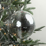 Large mirrored disco ball Christmas ornament featuring shimmering silver tiles, perfect for festive holiday decorating.