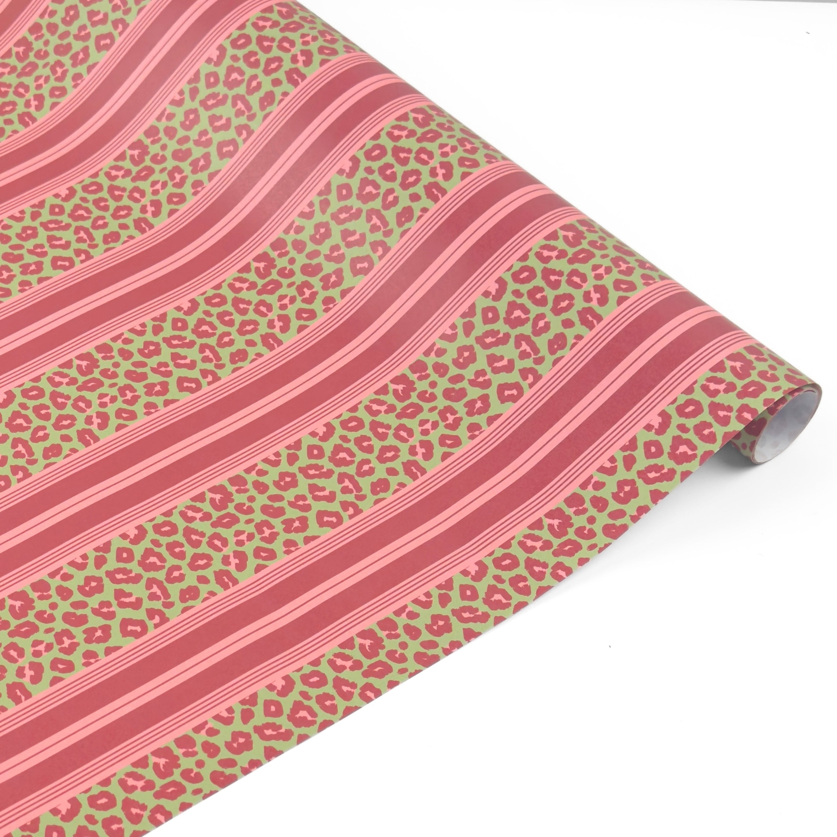 Stylish gift wrap featuring bold pink leopard prints, vibrant green accents, and elegant striped patterns.