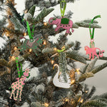 Hand-painted animal Christmas ornaments featuring a zebra, elephant, monkey, giraffe, and swan in festive colors.