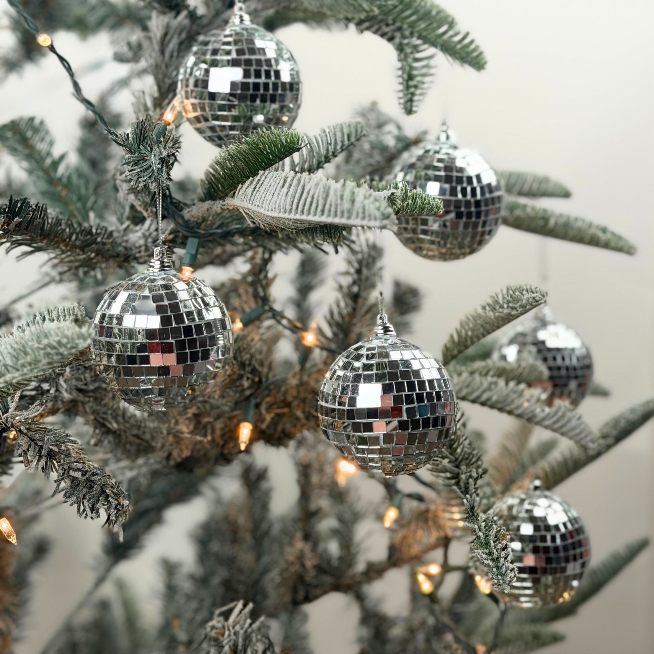 six silver disco ball christmas ornaments on a white background