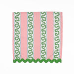 Pink cloth dinner napkins featuring green wavy stripes, blue dotted accents, and green scalloped trim.