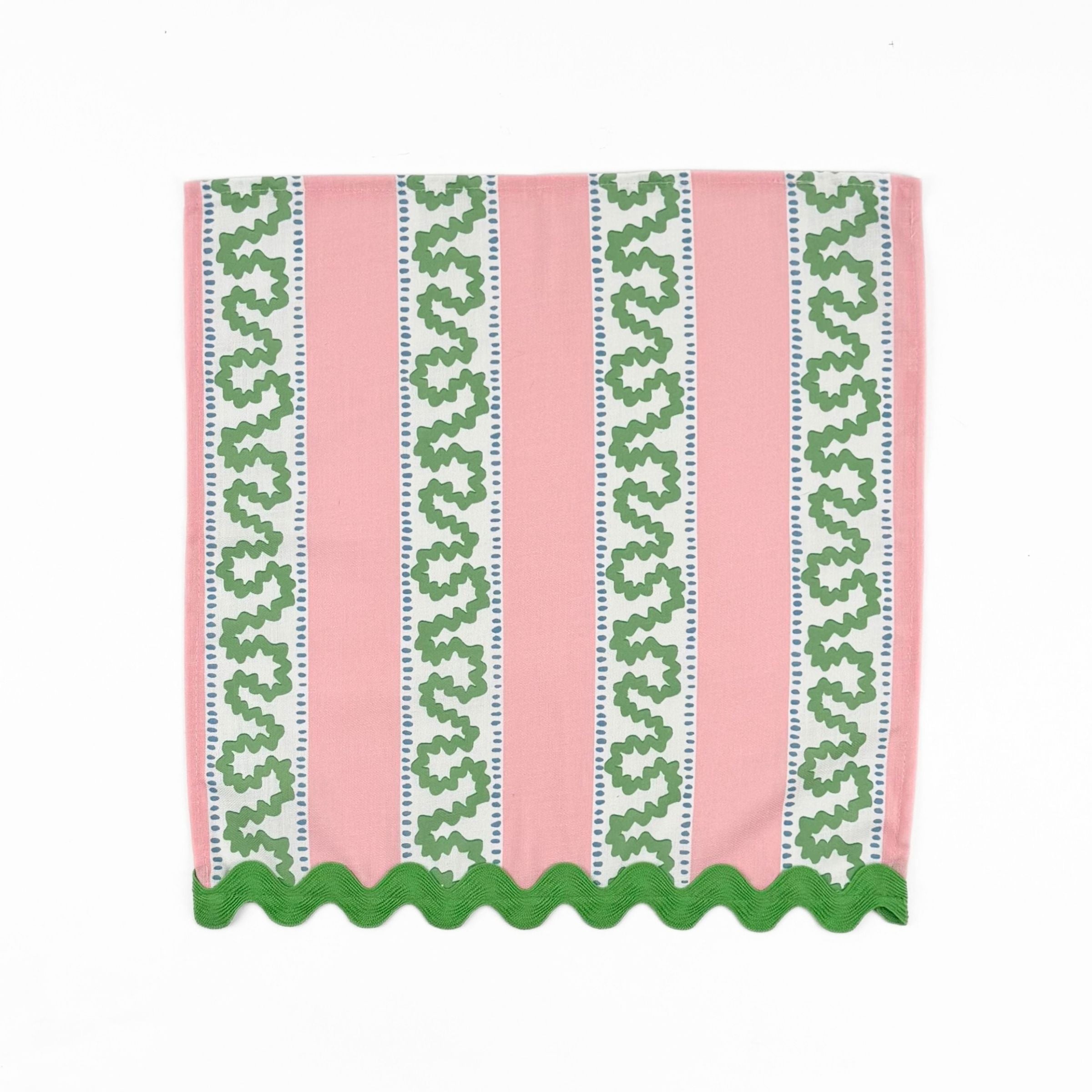 Pink cloth dinner napkins featuring green wavy stripes, blue dotted accents, and green scalloped trim.