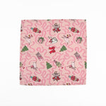Pink Christmas dinner napkins featuring swirling ribbons, nutcrackers, ballerinas, festive gifts, and whimsical holiday illustrations.