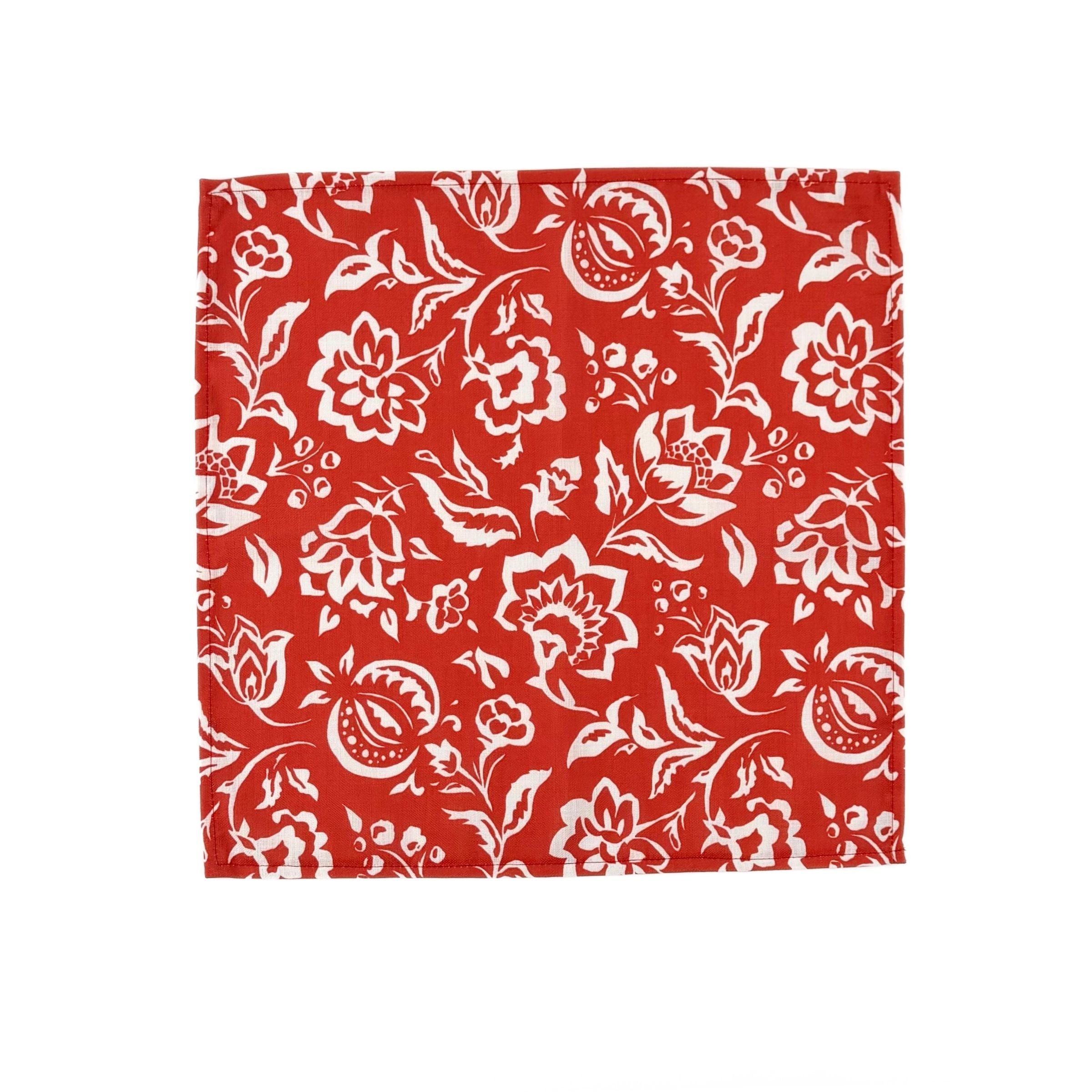 Red cloth dinner napkins featuring intricate white block print floral patterns for elegant table settings.