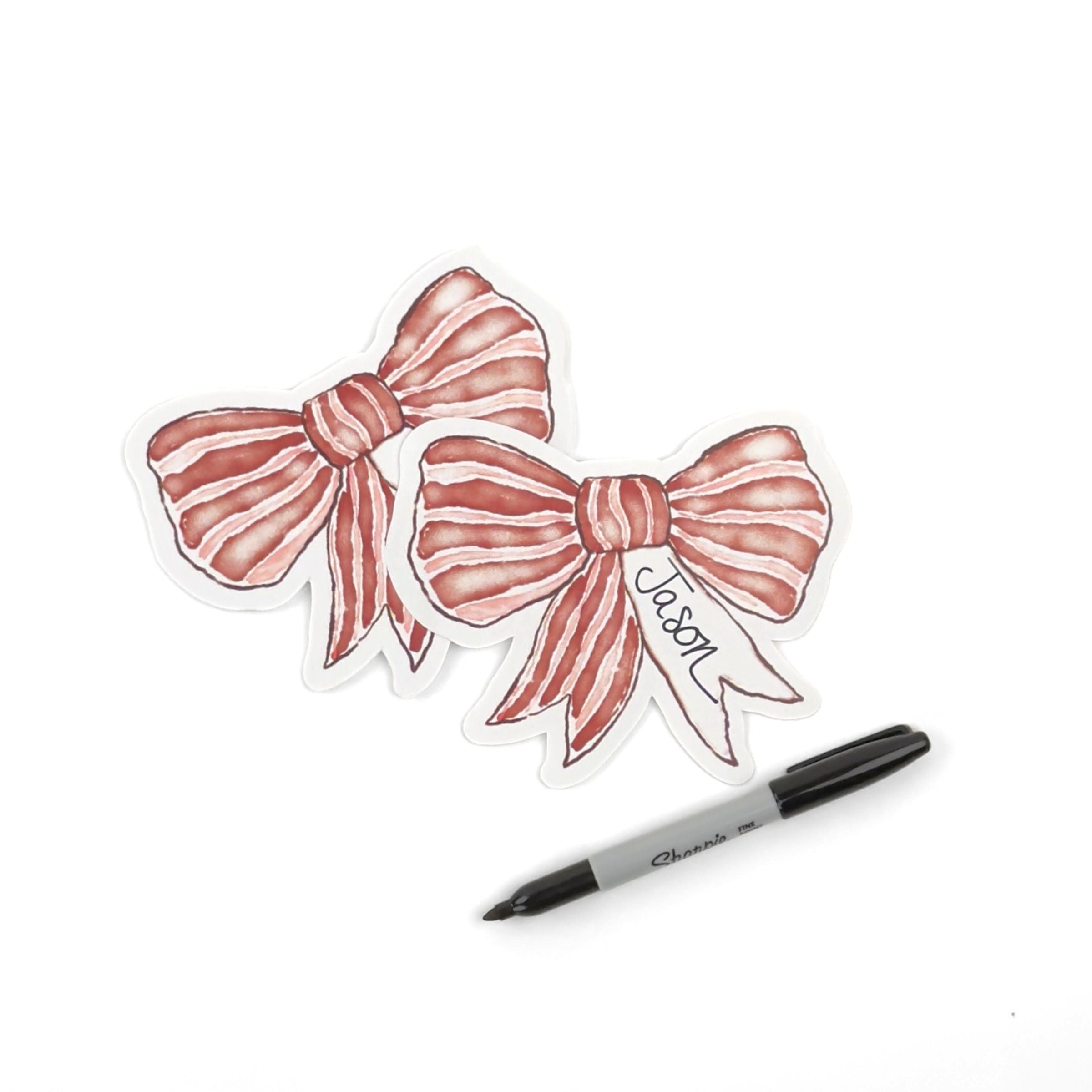 Two Elegant red bow place cards featuring delicate white stripes and personalized names for festive table settings.