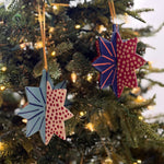 Hand-painted wooden patriotic star ornaments featuring red, white, and blue designs with decorative gold hanging cords.