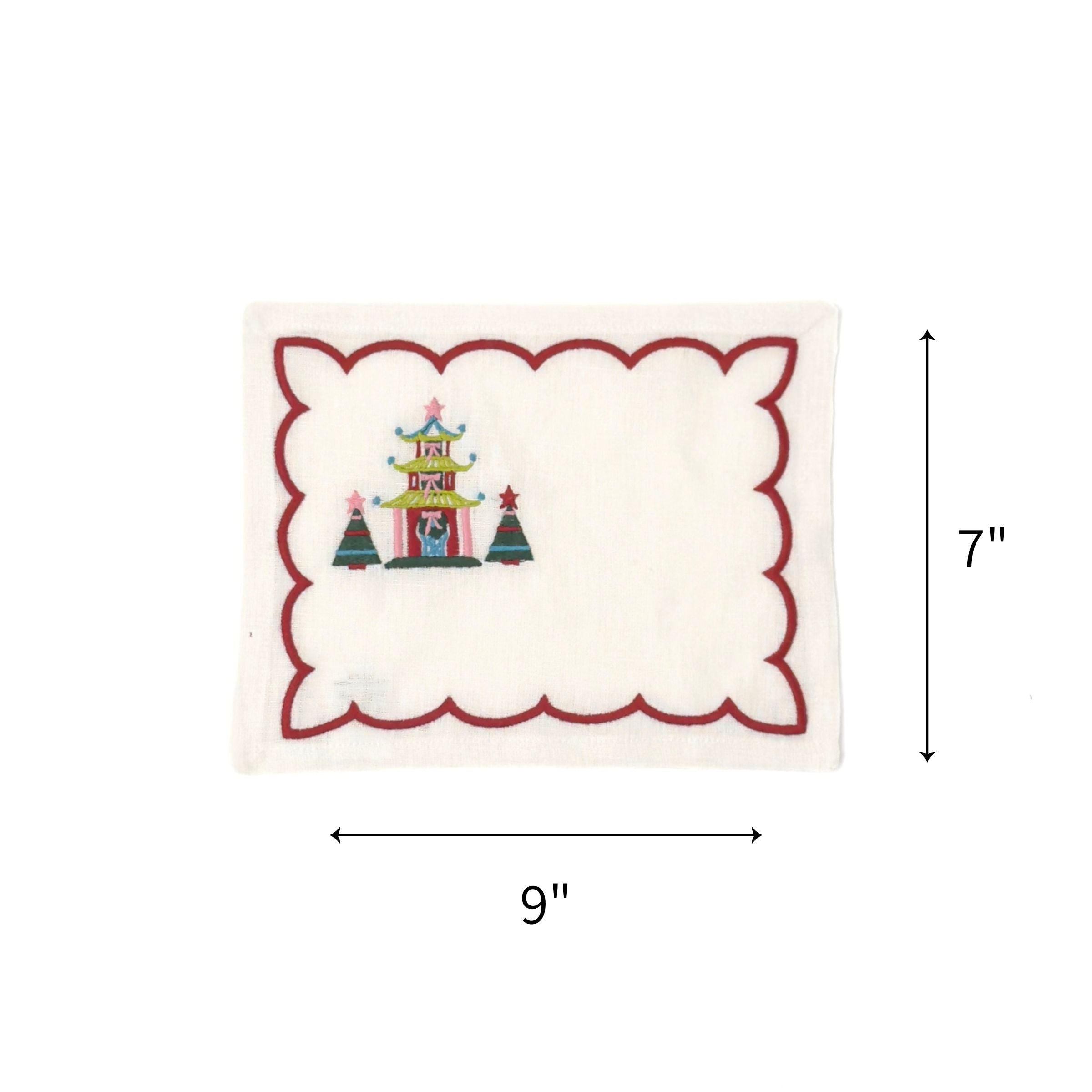 Elegant white cocktail napkins featuring red scalloped borders, colorful Christmas pagodas, festive trees, and embroidery with dimensions of 7" by 9"