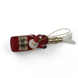 a santa riding a red champagne bottle ornament against a white background