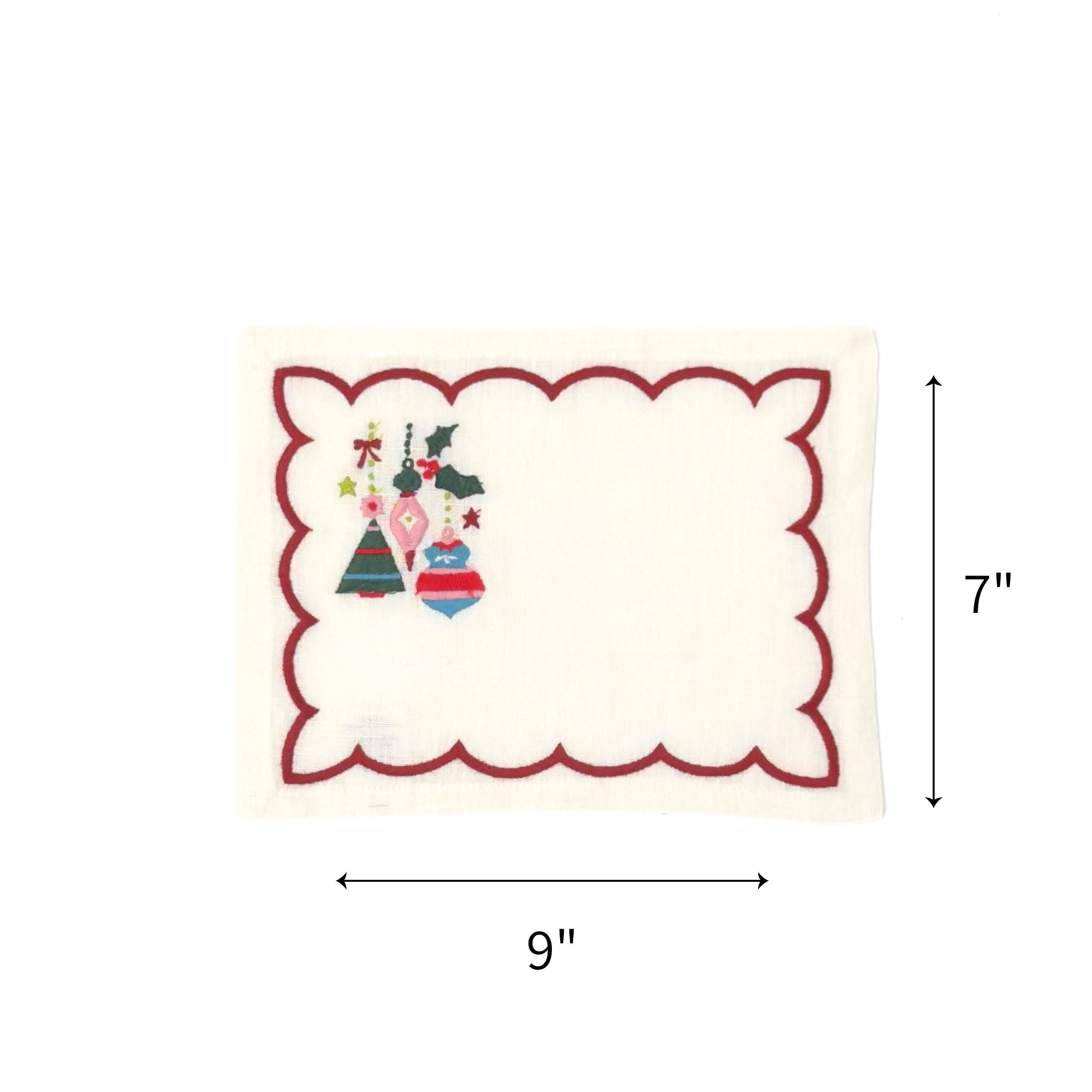 Elegant white cocktail napkins featuring red scalloped borders, colorful Christmas ornaments, holly, and festive embroidery with dimensions of 7" by 9"