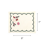 Elegant white cocktail napkins featuring green scalloped borders, embroidered Santa faces, holly, and pink ornaments with dimensions of 7" by 9"