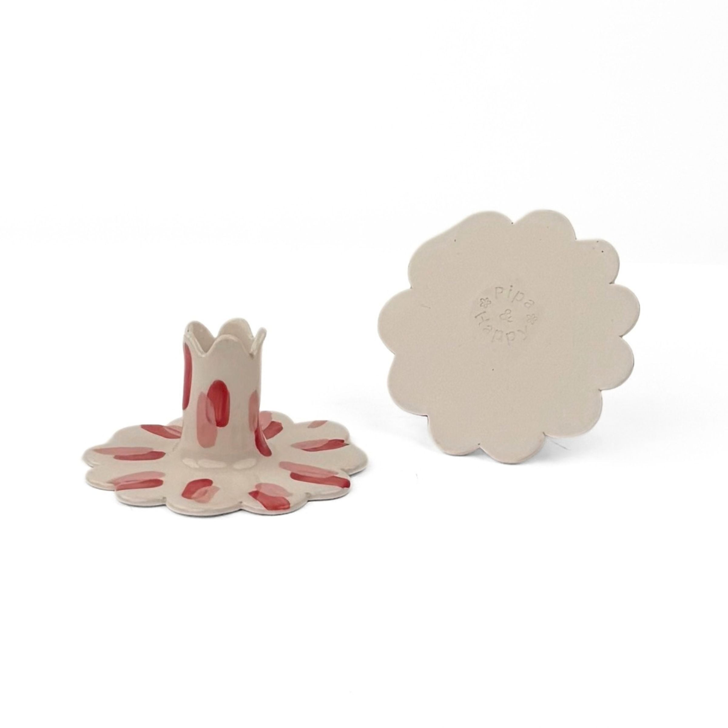 a red and white ceramic petal-shaped candle holders with hand-painted red accents, shown alongside its matching back piece on a white background.