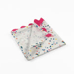 Folded White cloth dinner napkins featuring playful multicolor confetti dots and bright pink ric rac trim.