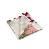 Folded White cloth dinner napkins featuring pink strawberries, green leaves, and red scalloped trim for tablescapes.
