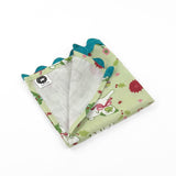 Folded Light green Christmas dinner napkins featuring festive pugs, holiday decorations, and bright turquoise ric rac trim.
