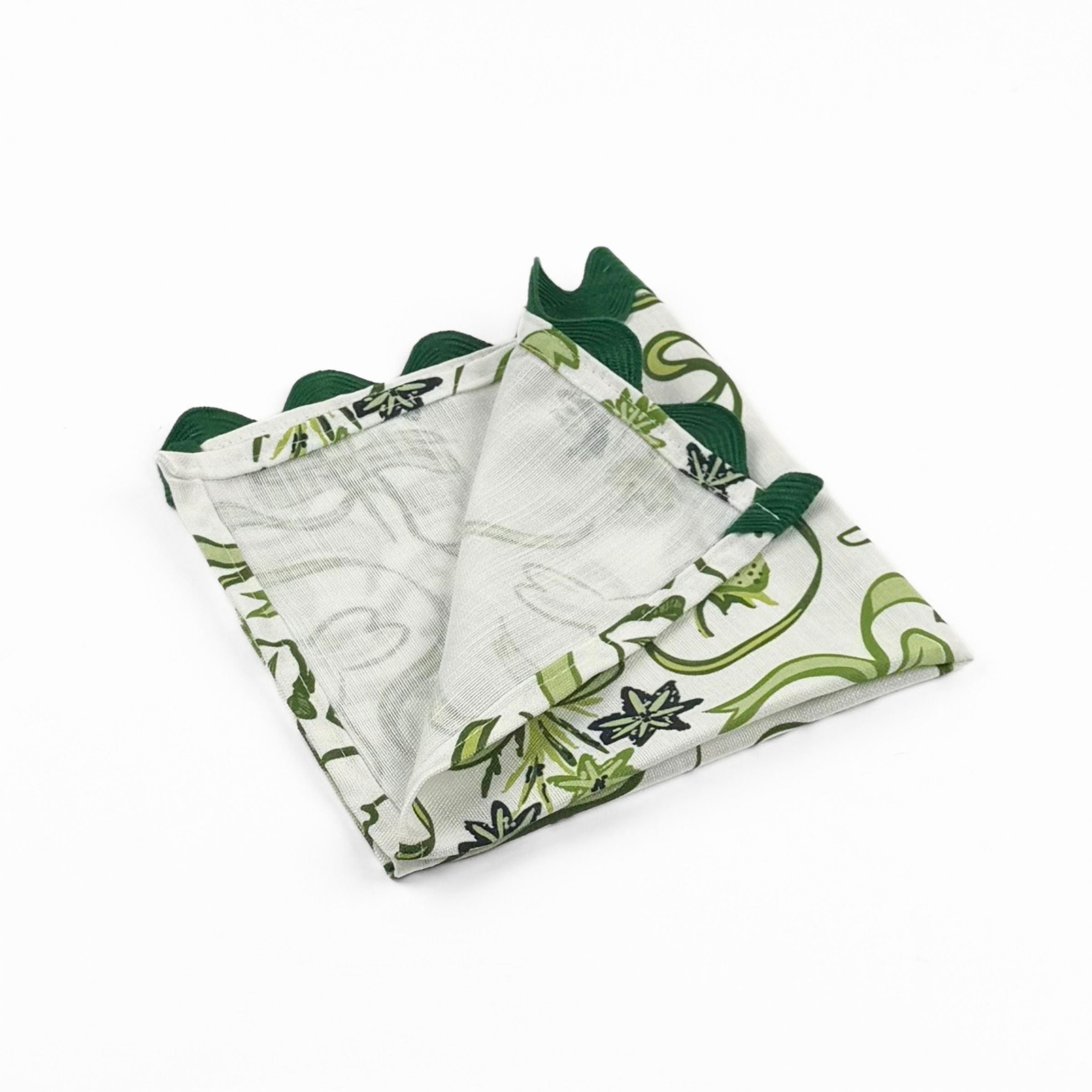 Folded White dinner napkins featuring green bunnies, bows, strawberries, floral patterns, and dark green ric rac trim.