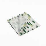 Folded White cloth dinner napkins featuring abstract green brushstroke patterns in varying shades for stylish tablescapes.