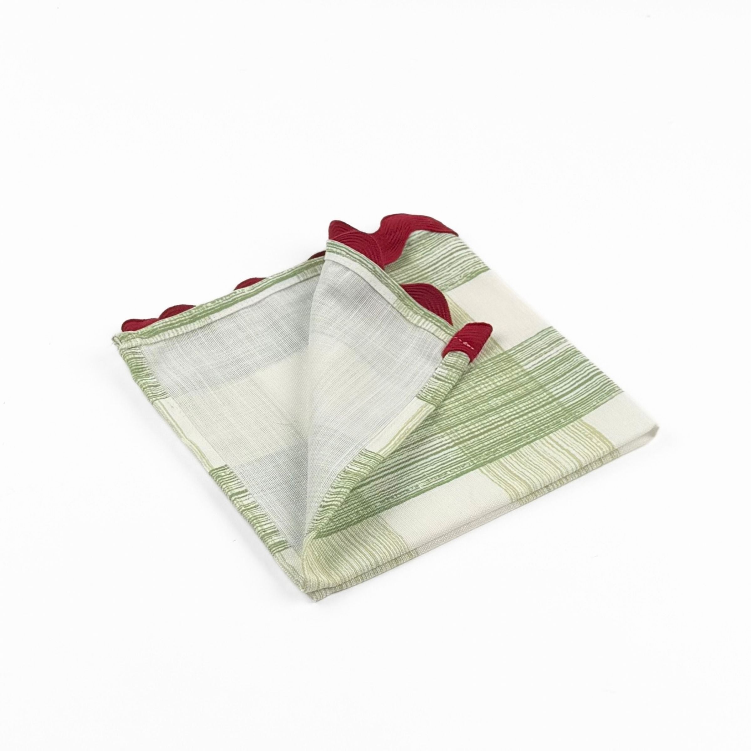 Folded Green and white gingham cloth dinner napkins featuring red scalloped trim for charming holiday tablescapes