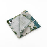 Folded Elegant cloth dinner napkins featuring traditional chinoiserie landscapes in soft green, blue, and ivory tones.