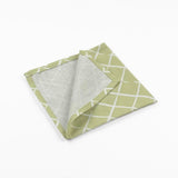 Folded Light green cloth dinner napkins featuring a delicate white lattice pattern for elegant table settings.
