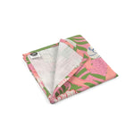 Folded Pink cloth dinner napkins featuring colorful seashells, tropical green foliage, and playful coastal inspired patterns.