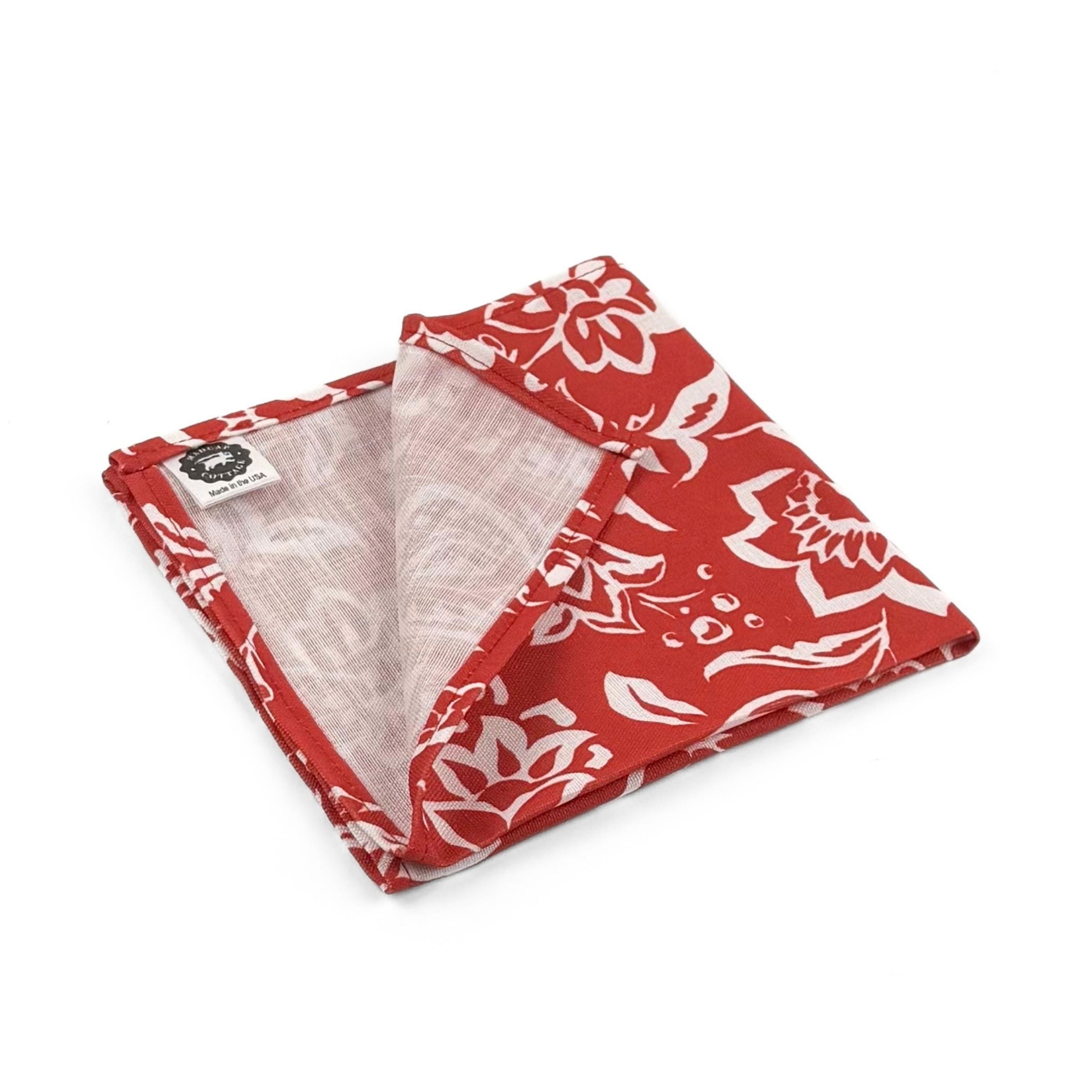 Folded Red cloth dinner napkins featuring intricate white block print floral patterns for elegant table settings.
