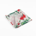 Folded White cloth dinner napkins featuring vibrant red geranium flowers and lush green leaves for tablescapes.