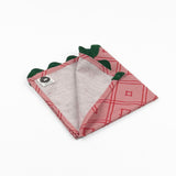 Folded Pink cloth dinner napkins featuring red bamboo trellis patterns and dark green scalloped trim accents.