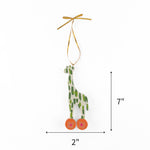 Wooden giraffe Christmas ornament featuring green spots and colorful wheels, measuring 7" by 2"