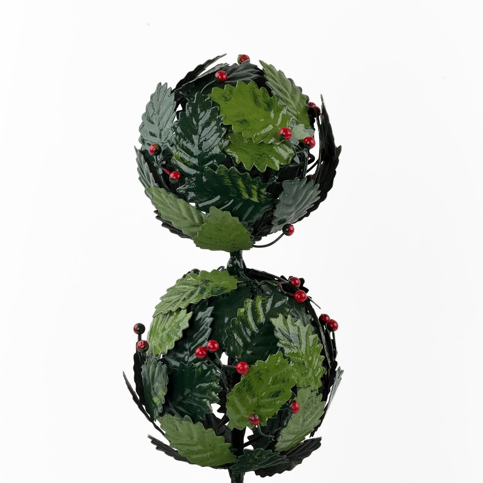 a close up of  tole metal three tiered holly topiary ball centerpiece with glossy leaves in two shades of green and small berry accents throughout. 
