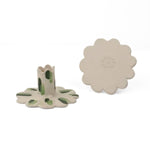 Set of two white ceramic scalloped taper candle holders with green brushstroke accents, shown from the top and side angles on a light background.