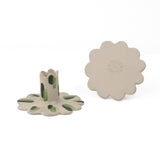 Set of two white ceramic scalloped taper candle holders with green brushstroke accents, shown from the top and side angles on a light background.