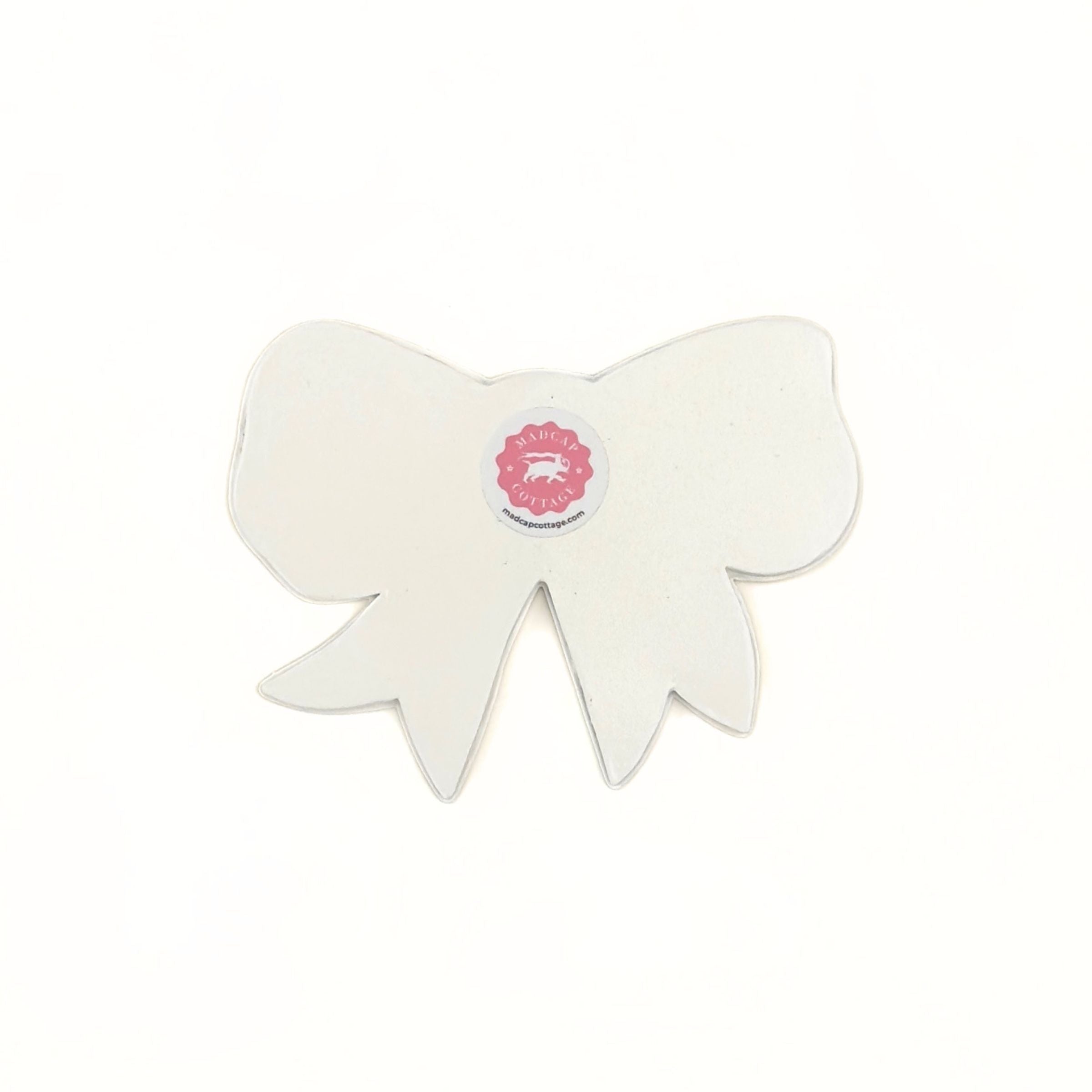 Back view of a bow-shaped tray showing the plain finish and maker label.