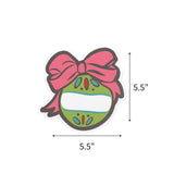Festive ornament place card featuring a green Christmas bauble, pink bow, and personalized name space. with dimension arrows and labels indicating 5.5" by 5.5"