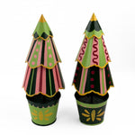 A set of two tole metal Christmas Tree Centerpieces patterned with stripes, scallops and spots in green and yellow painted bases in Madcap Cottag motifs. 