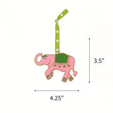 Hand-painted pink elephant Christmas ornament featuring green details, measuring 3.5" by 4.25"