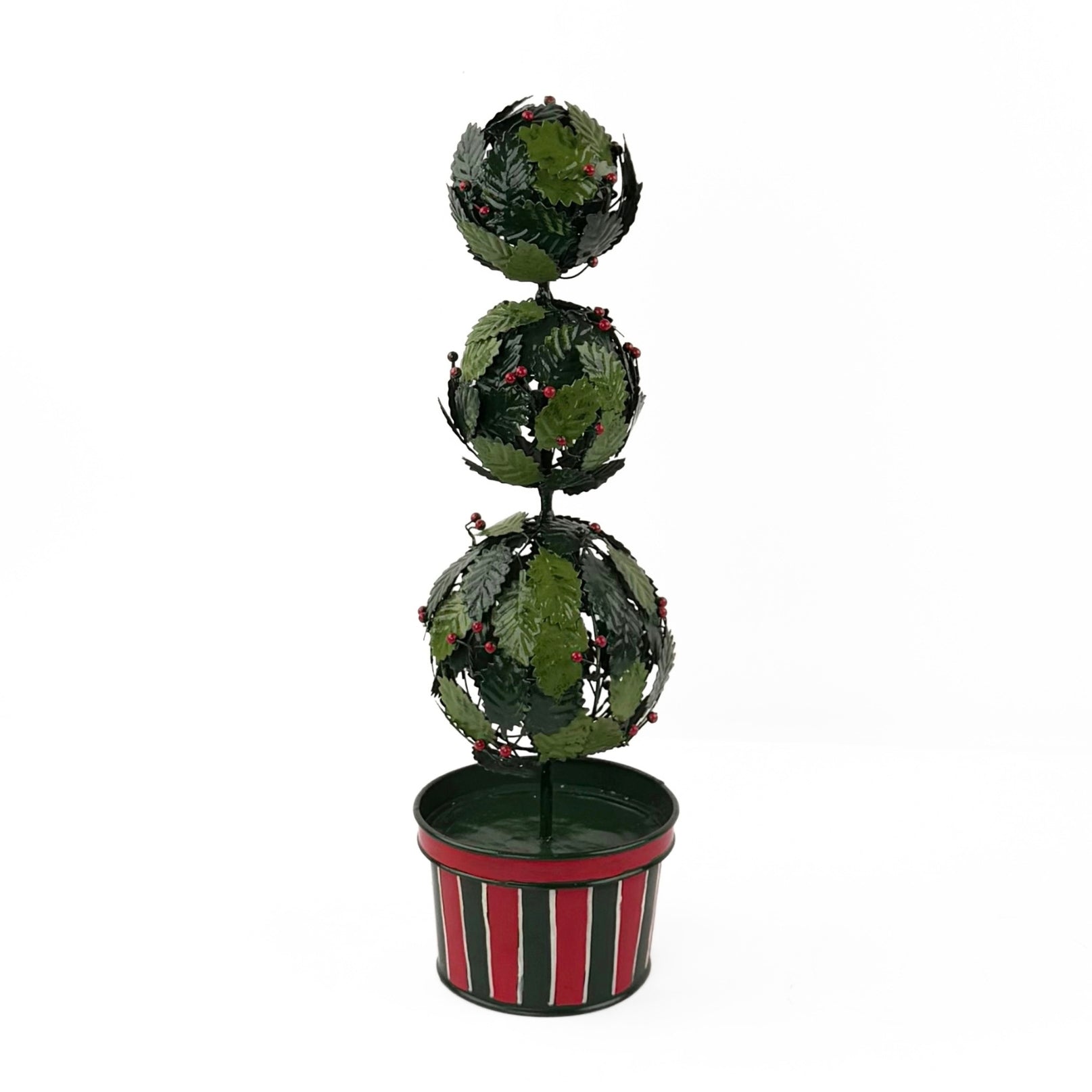 A tole metal three tiered holly topiary ball centerpiece with a striped red and green pot forming the base. 