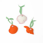 back of Handcrafted Pink Orange Shells Felt Christmas Ornaments featuring coral spiral, conch, and red scallop shell designs with green gingham ribbons.