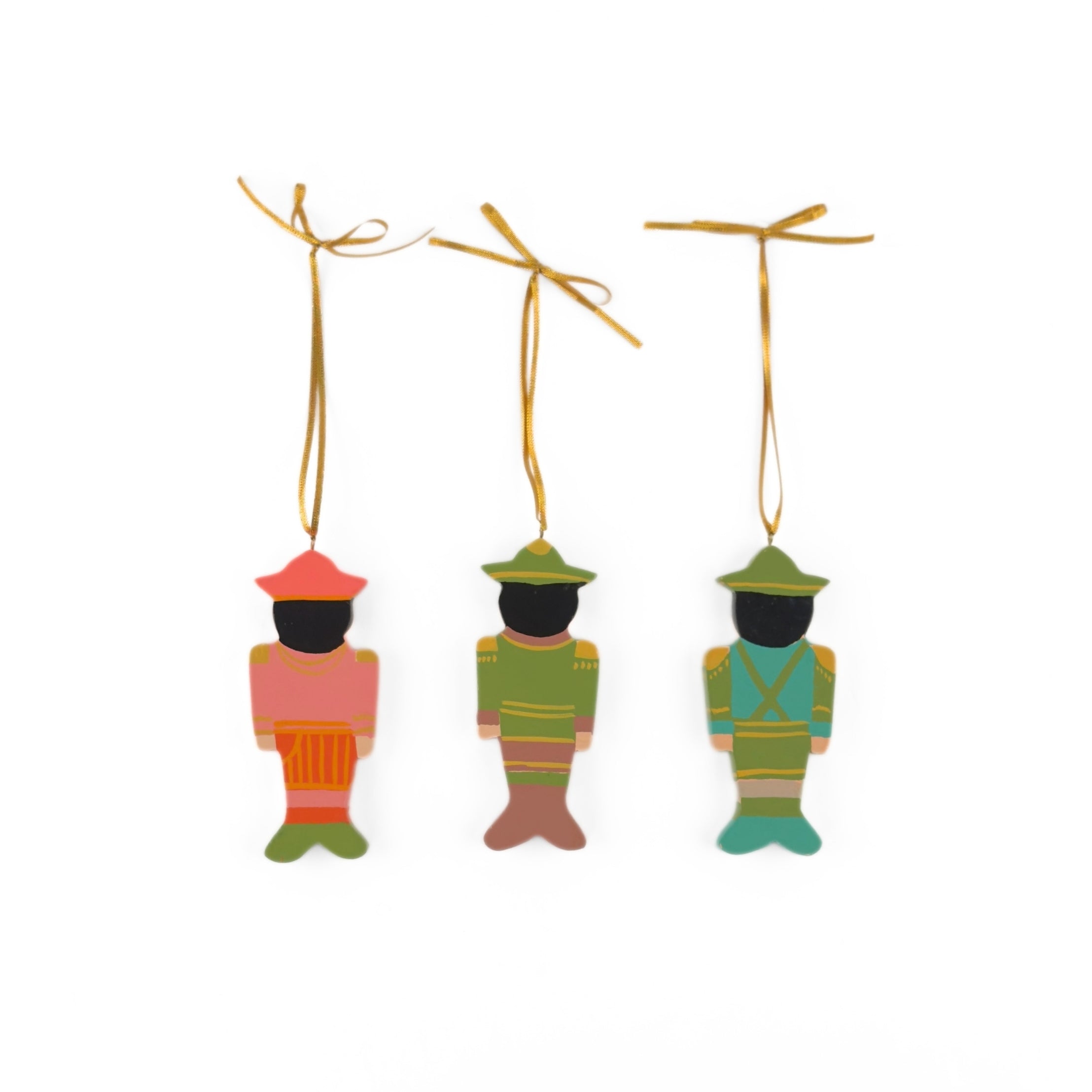Back view of three Festive hand-painted wooden nutcracker Christmas ornaments featuring colorful soldier designs and gold hanging cords for decorating.