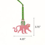 Hand-painted pink monkey Christmas ornament featuring green accents, measuring 3.75" by 4.25"