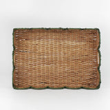 Rattan tray with scalloped edge and green trim on a white background