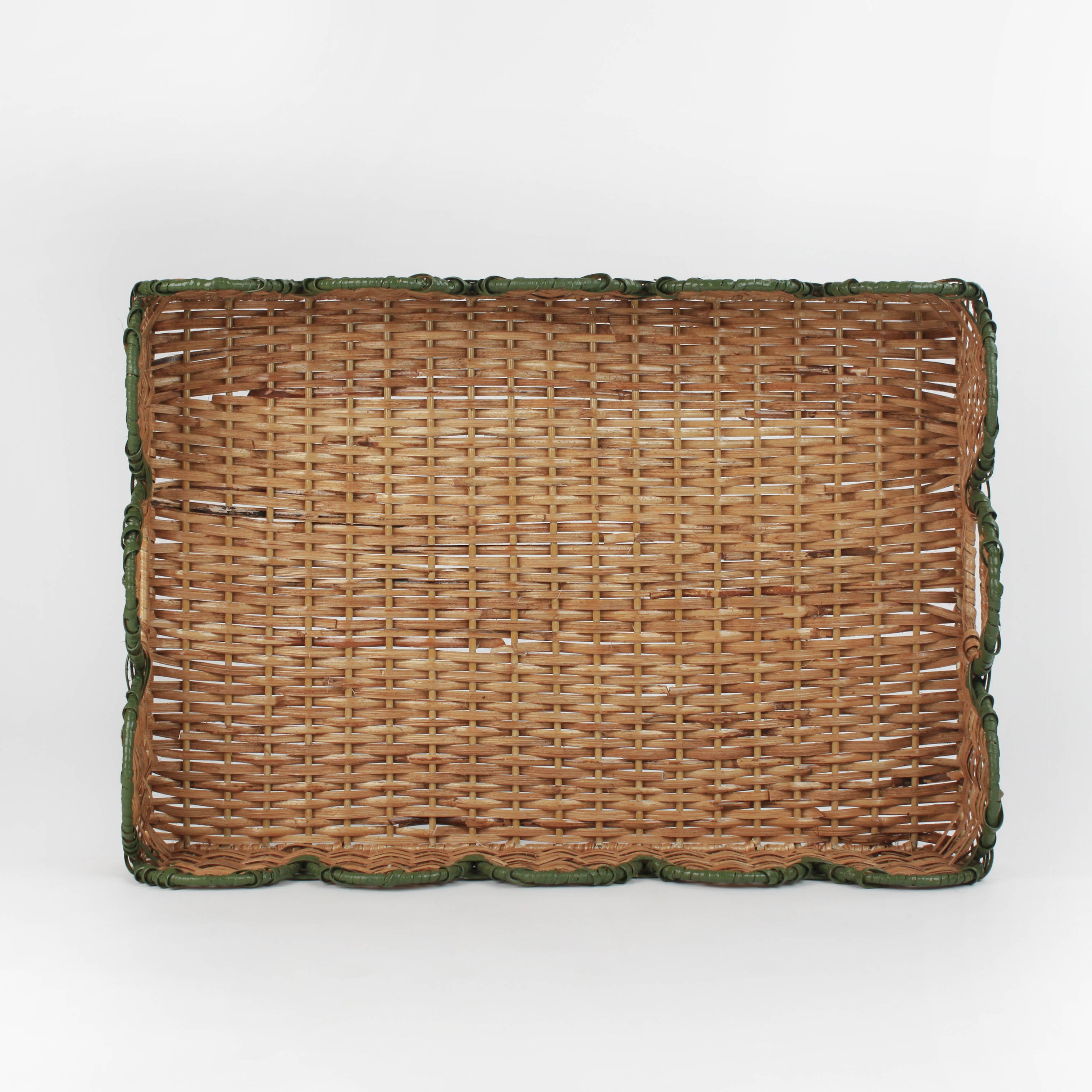 Rattan tray with scalloped edge and green trim on a white background