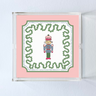 a square acrylic tray featuring a pink border and central nutcracker motif. 