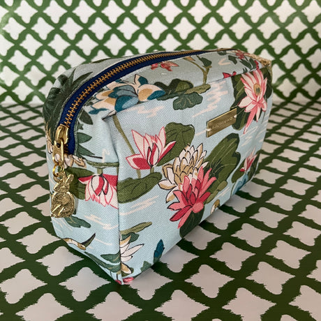 Front 3/4 view of Meadow Club toiletry bag in sky blue features a lily pond pattern