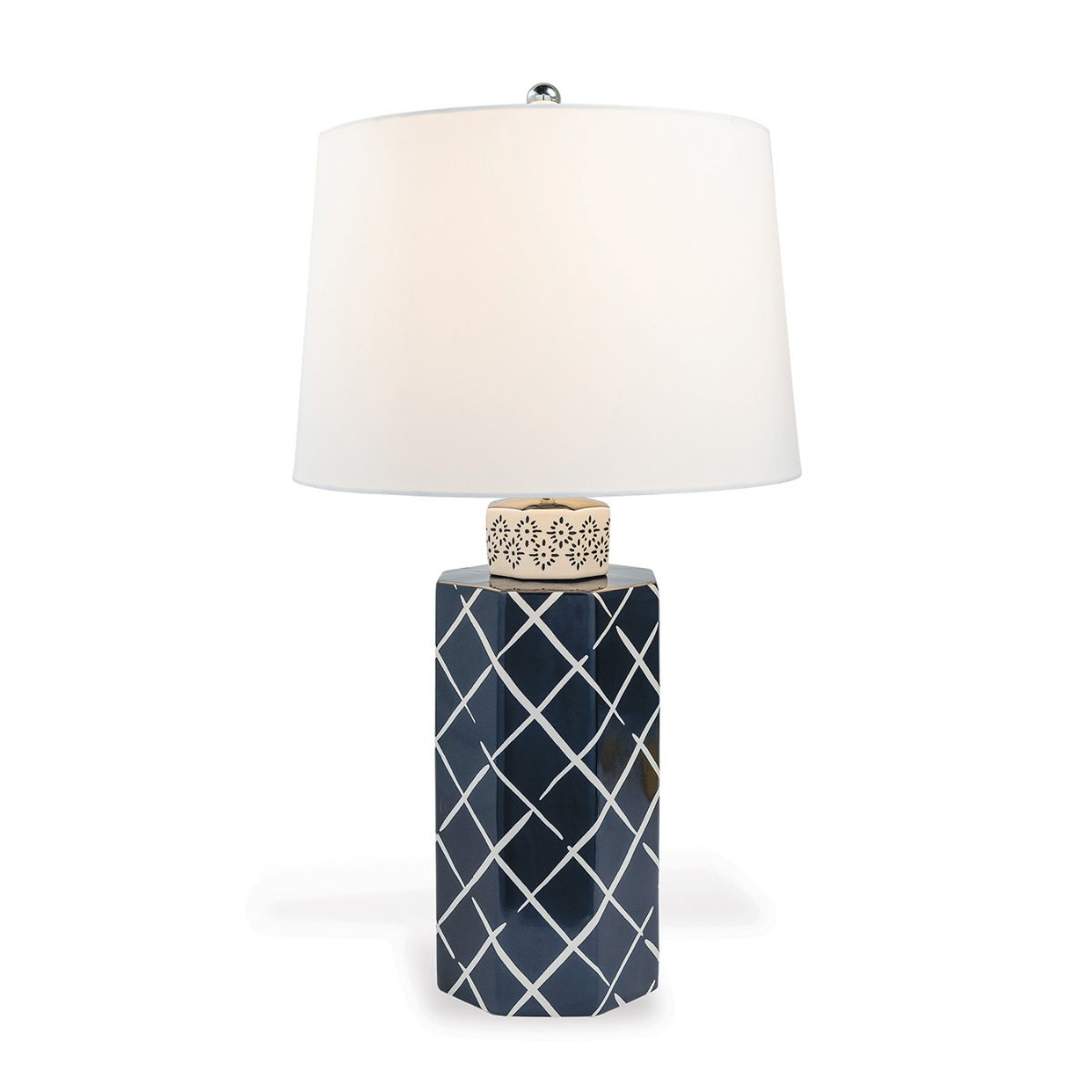 A navy blue and white table lamp with a navy blue porcelain base featuring a white lattice pattern and a plain white lampshade. 