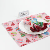 Bamboo Trellis Paper Place Card in pool blue shown on a festive Christmas table setting with pink holiday placemat and nutcracker napkin ring.