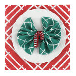 Island House square red paper placemats in a white background. A white plate is placed on top of it with a cloth and a rattan candy cane napkin ring