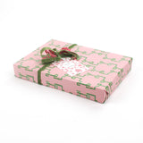 Flat wrapped gift using Bamboozled green and pink wrapping paper with ribbon and tag.
