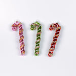 three glass candy cane ornaments on a white background